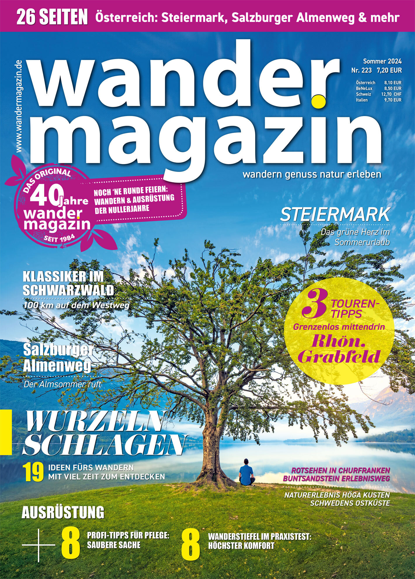 Sommercover des Magazins „Wandermagazin“ für 2024. Im Zentrum ein alleinstehender Baum vor blauem Himmel und Bergen, mit einem See in der Ferne. Themen: Wanderungen in der Steiermark, Schwarzwald, Salzburger Almenweg.