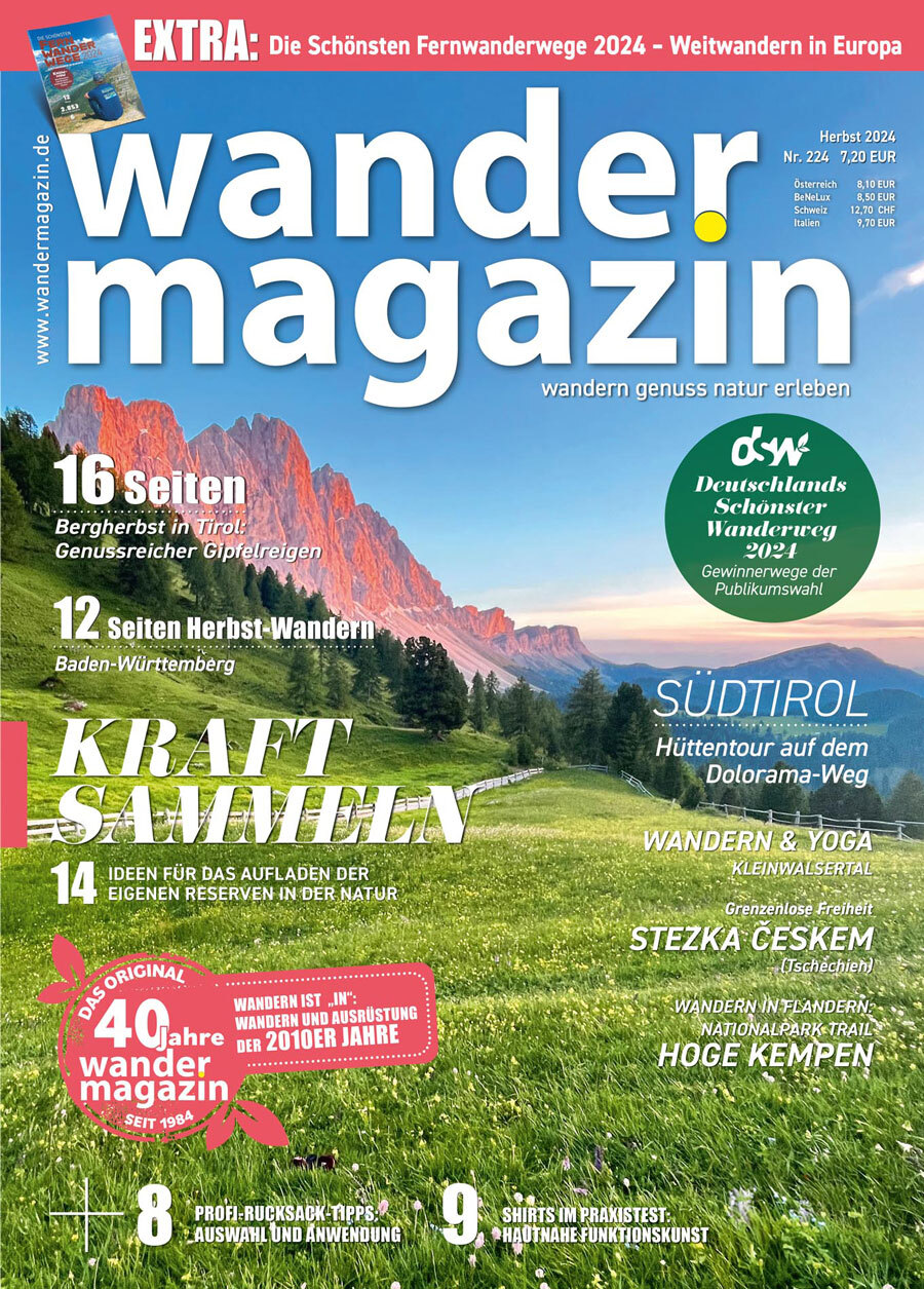 Herbstcover des Magazins „Wandermagazin“ für 2024. Im Hintergrund majestätische Berge und ein grünes Tal mit Bäumen. Themen: Wanderungen in Tirol, Baden-Württemberg, Stezka Českem.